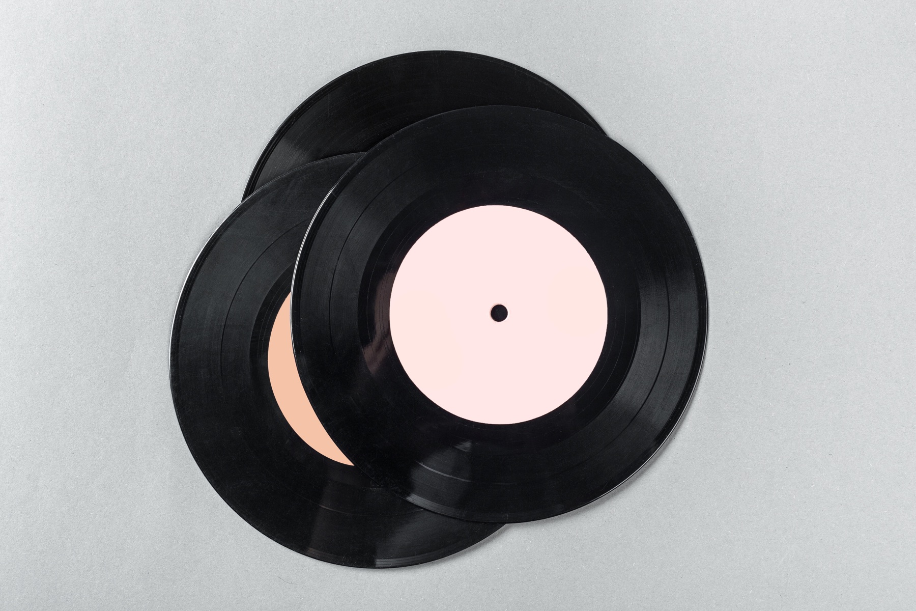 Two black vinyl records with pale pink centre labels